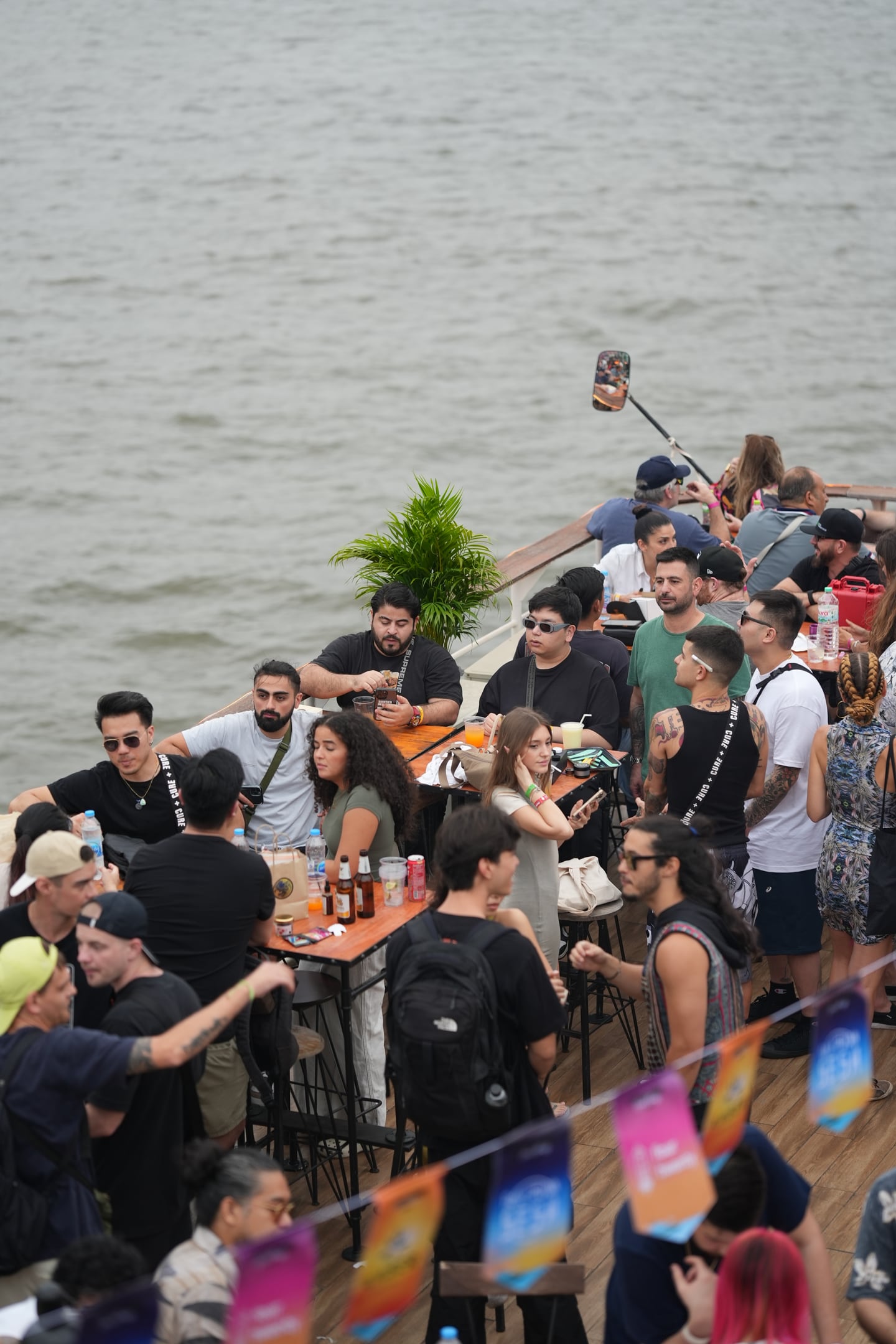 Guests socializing at an outdoor FOURTWENTY community gathering beside the water.